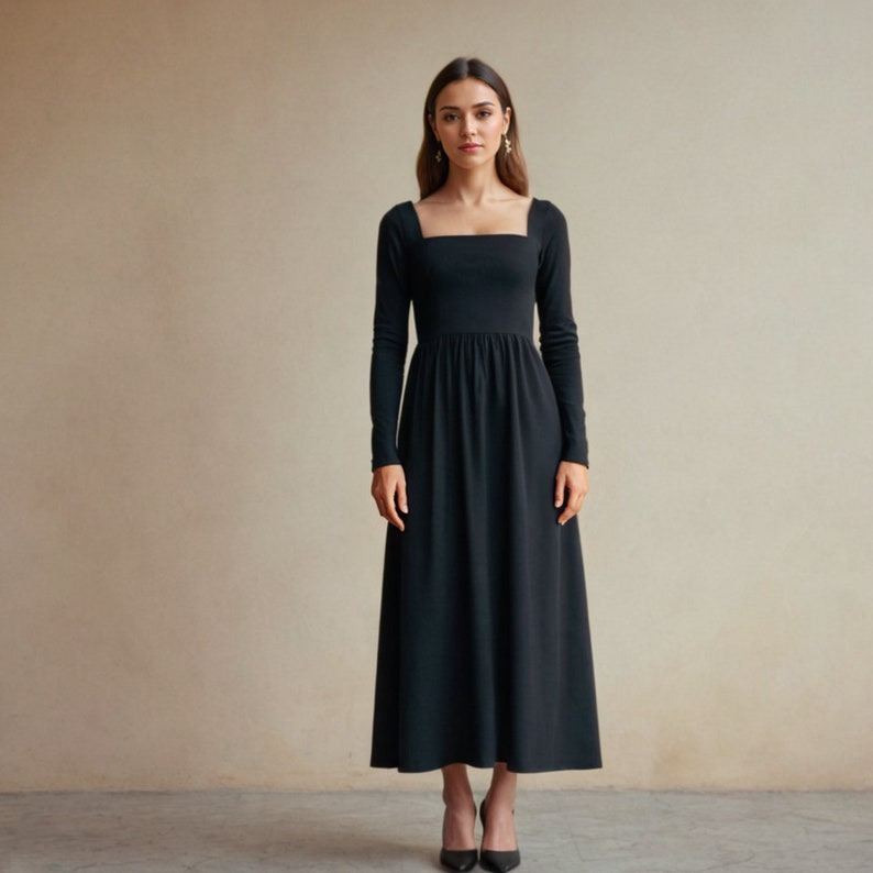 K&ouml;nnte beinhalten: Ein langes schwarzes Kleid mit quadratischem Ausschnitt und langen &Auml;rmeln. Das Kleid hat ein eng anliegendes Oberteil und einen flie&szlig;enden Rock, der bis zur Mitte der Wade reicht. Das Model tr&auml;gt schwarze Abs&auml;tze. Der Hintergrund ist ein neutraler beigefarbener Ton.