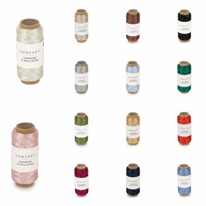 Könnte beinhalten: Eine Sammlung von Spulen mit dekorativem Garn in verschiedenen Farben, darunter Weiß, Gold, Silber, Blau, Grün und Rot. Jede Spule hat einen Holzkern und ein Etikett mit der Aufschrift "CONCEPT COMBINE & PAILLETTES".