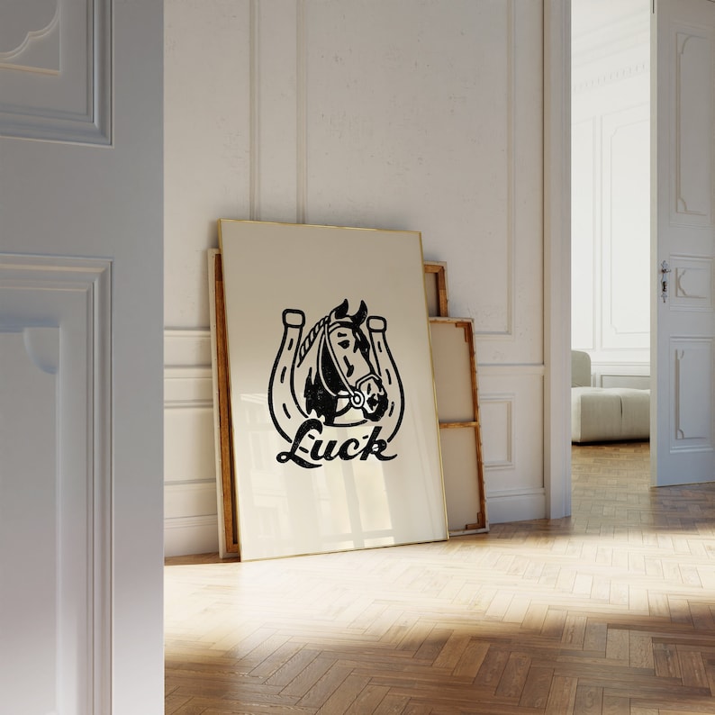 May include: Black and white illustration of a horse's head inside a horseshoe with the word "Luck" printed below. The illustration is on a white framed canvas.