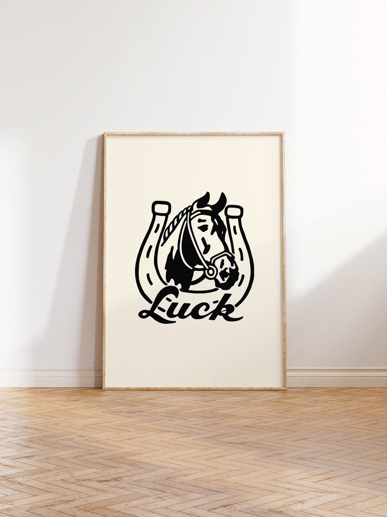 May include: Black and white illustration of a horse's head inside a horseshoe with the word "Luck" written below.