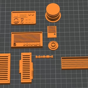 May include: An assortment of orange 3D-printed components, including rectangular panels with horizontal slats, a circular stack, and a control panel with buttons and dials. The pieces are arranged on a gray grid background.