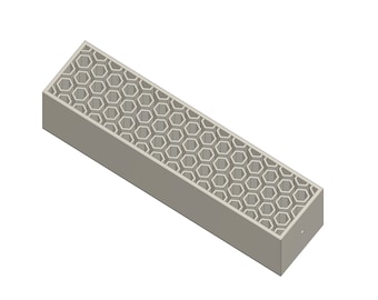 May include: A gray rectangular box with a honeycomb pattern on the inside. The box is made of plastic and has a smooth surface.