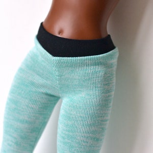 K&ouml;nnte beinhalten: Eine tealfarbene Leggings mit schwarzem Bund. Die Leggings hat einen dezenten wei&szlig;en Schimmer im gesamten Stoff.