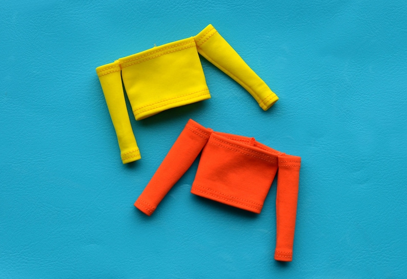 May include: Two off-the-shoulder tops, one yellow and one orange, on a blue background.
