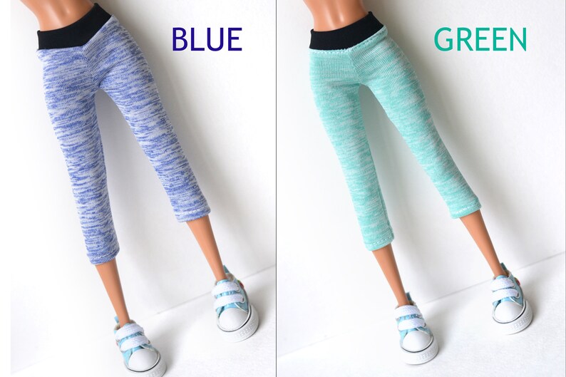 K&ouml;nnte beinhalten: Zwei Paar Leggings in Puppengr&ouml;&szlig;e, eine blaue und eine gr&uuml;ne, mit einem schwarzen Bund. Die Leggings haben ein marmoriertes Muster.