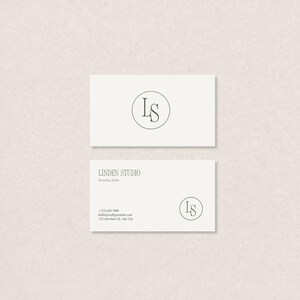 Könnte beinhalten: Zwei cremefarbene Visitenkarten. Die obere Karte zeigt ein kreisförmiges Logo mit den Buchstaben "LS" im Inneren. Die untere Karte hat dasselbe Logo, den Text "LINDEN STUDIO Branding Studio" und Kontaktinformationen.