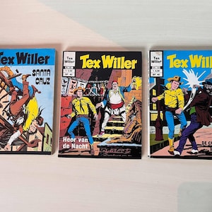 May include: Three vintage Tex Willer comic books. The covers feature colorful illustrations of cowboys and action scenes. Titles include "Santa Cruz", "Heer van de Nacht", and "De Cubaans Bende". Each comic has a blue border and the title "Tex Willer".