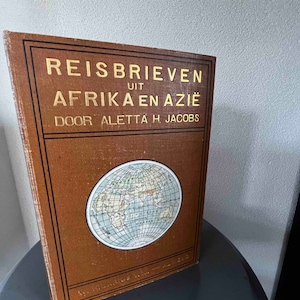 Könnte beinhalten: Ein braunes Buch mit goldenen Lettern mit dem Titel "Reisbrieven uit Afrika en Azië" von Aletta H. Jacobs. Der Umschlag zeigt eine Weltkarte.