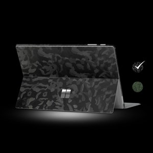 May include: A black laptop with a camouflage pattern on the lid. The laptop is closed and the screen is facing away from the viewer.