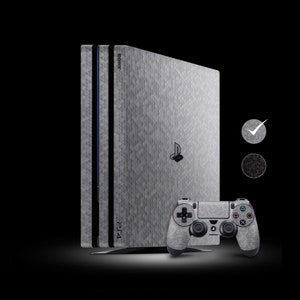 Könnte beinhalten: Eine graue und schwarze PlayStation 4 Konsole mit einer sechseckigen Musterhaut. Die Konsole befindet sich neben einem passenden grauen und schwarzen Controller mit dem PlayStation-Logo.