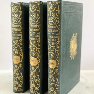 May include: Three antique green hardcover books with gold lettering and illustrations. The books are titled "Morris' Nests & Eggs of British Birds" and are labeled volumes I, II, and III.