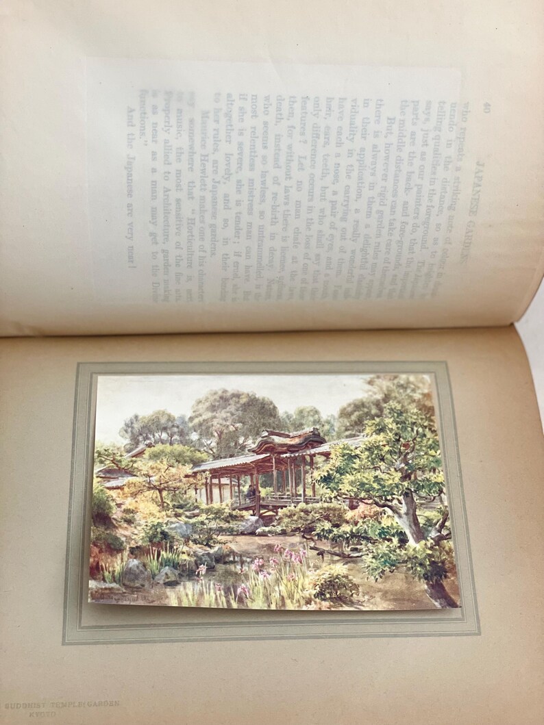 May include: A vintage print of a Japanese garden scene, featuring a traditional wooden structure over a pond. The artwork showcases lush greenery, trees, and a serene landscape, with text from a book visible.