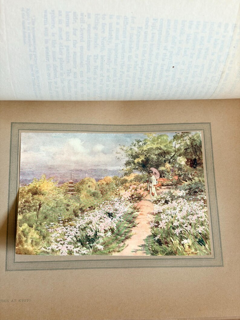 May include: A vintage watercolor print titled "Work at Kyoto" depicts a garden path lined with white flowers, leading to a figure with a parasol. The background shows a pagoda and lush greenery, with a soft, muted color palette.