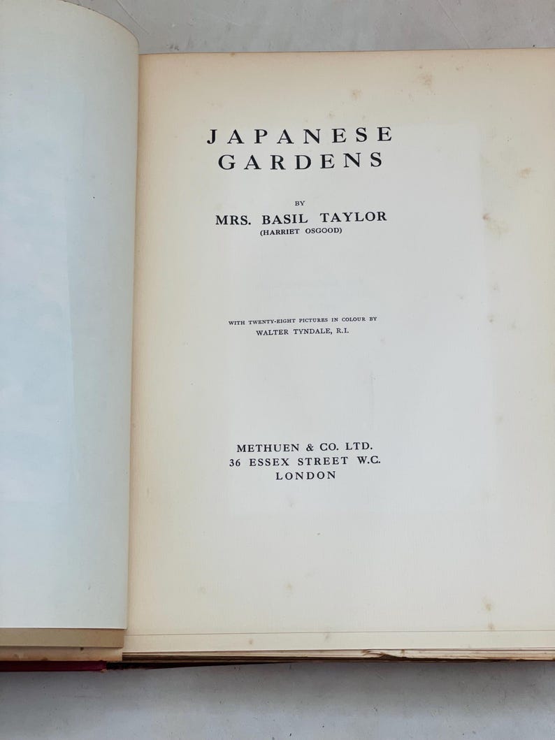 May include: Open book titled "Japanese Gardens" by Mrs. Basil Taylor. The cover features black text on an off-white page. The book includes information about the author and publisher, Methuen & Co. Ltd., located in London.
