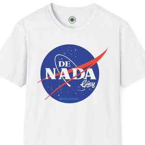 May include: White t-shirt featuring a blue and red NASA-inspired logo with the text "DE NADA Güey" and "MEXILICIOUS" in white.