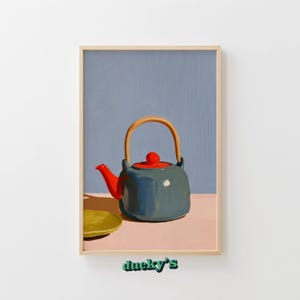 Puede incluir: Una lámina enmarcada con la pintura de una tetera azul oscuro con tapa y boquilla de color rojo brillante, un asa de madera clara y un pequeño platillo amarillo. La obra tiene un fondo azul apagado y una superficie rosa suave. Texto ducky's visible.