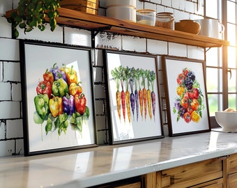 Puede incluir: Tres acuarelas enmarcadas de verduras colgadas en una pared de azulejos blancos en una cocina. Las pinturas representan un ramo de pimientos de colores, una fila de zanahorias naranjas y moradas y un racimo de tomates rojos y morados.