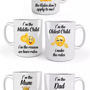 May include: Set of four white ceramic mugs with humorous family-themed designs. Each mug features a different emoji and text, including "I'm the Youngest Child", "I'm the Middle Child", "I'm the Oldest Child", "I'm the Mum", and "I'm the Dad".
