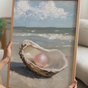 Könnte beinhalten: Ein Gemälde einer Muschel mit einer großen rosa Perle darin, auf einem Sandstrand mit blauem Himmel und weißen Wolken im Hintergrund.