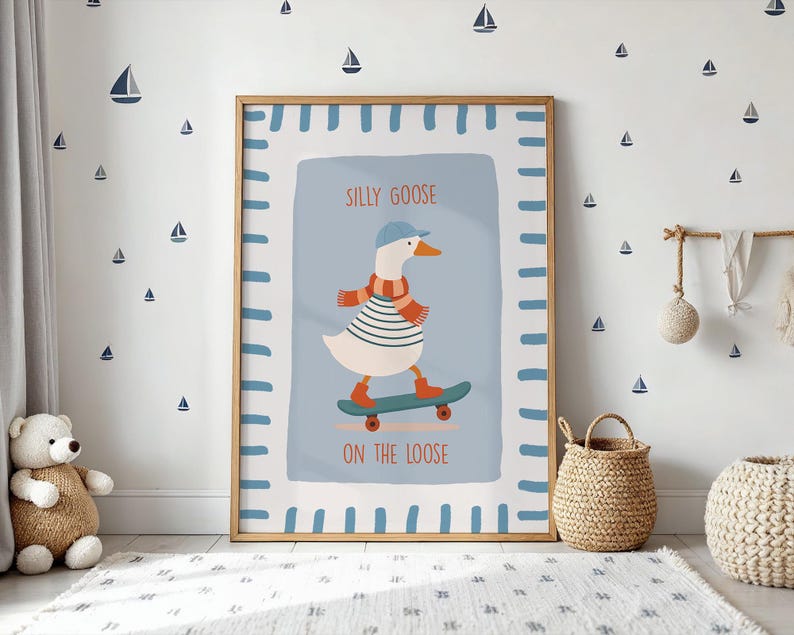 May include: A framed art print depicting a goose on a skateboard. The goose is dressed in a striped top, scarf, and cap. The text reads "SILLY GOOSE ON THE LOOSE". The background is light blue with a white border.
