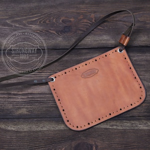 May include: A brown leather tool pouch with a dark brown strap and a silver metal buckle. The pouch has a stitched design and the text "Strongway Tools" is printed on the strap.