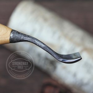 May include: A curved wood carving tool with a wooden handle and a metal blade. The blade is slightly curved and has a sharp edge. The tool is made by Strongway Tools, a company that specializes in handmade tools.