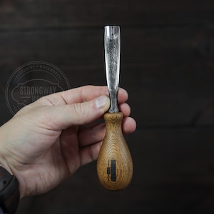 May include: A wood carving tool with a wooden handle and a metal blade. The handle is engraved with the words "Strongway Tools".