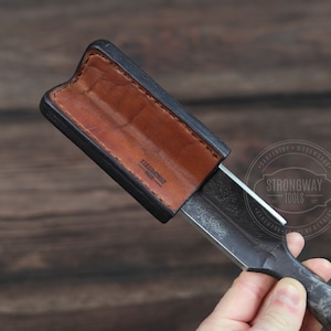 May include: A black leather sheath with a brown leather lining, holding a metal chisel with the text "Strongway Tools" on the handle.