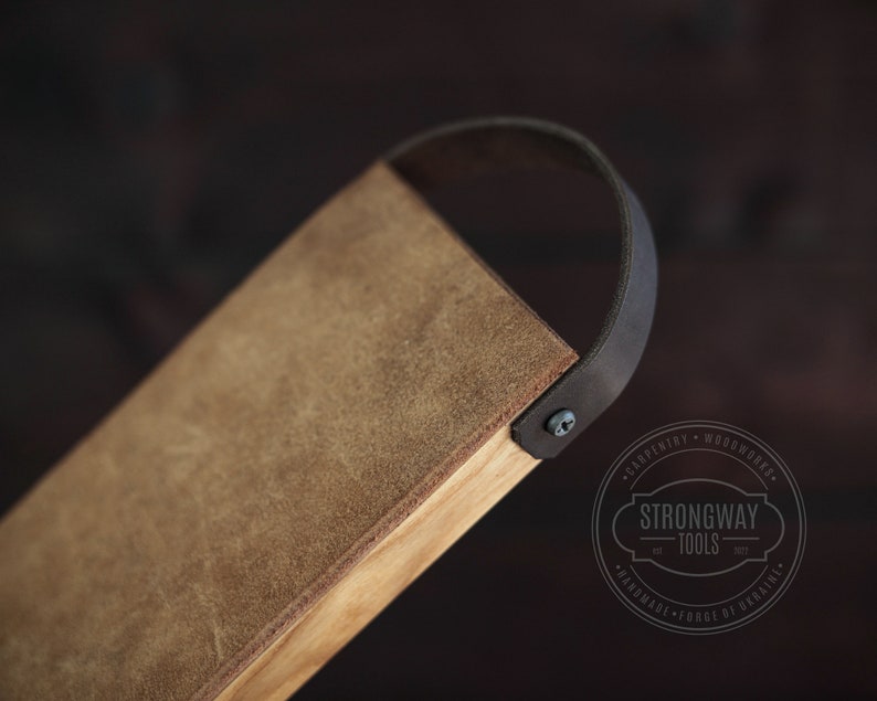 May include: A brown leather-wrapped wooden tray with a black leather handle. The tray has a distressed look and is made by Strongway Tools.