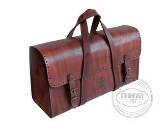 May include: A brown leather tool bag with two buckles and a handle. The bag has a label that says "Strongway Tools" and "Handmade - Forge of Ukraine".