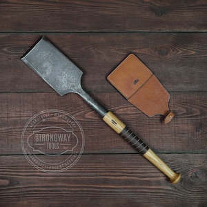 Könnte beinhalten: Ein Holzgriff-Meißel aus Metall mit einer Lederscheide. Der Meißel wird von Strongway Tools hergestellt.