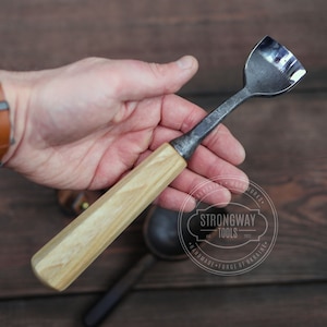 May include: A wooden handled carving tool with a curved metal blade. The tool is made by Strongway Tools, Handmade Forge of Ukraine.