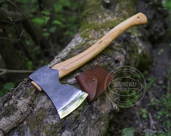 May include: A hand-forged axe with a wooden handle and a leather sheath. The axe is made by Strongway Tools, a handmade forge in Ukraine.