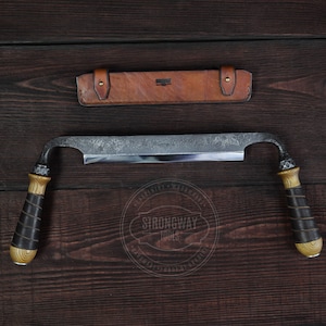 May include: A hand-forged woodworking tool with a curved blade and wooden handles. The tool is made by Strongway Tools and is shown on a dark wood background.