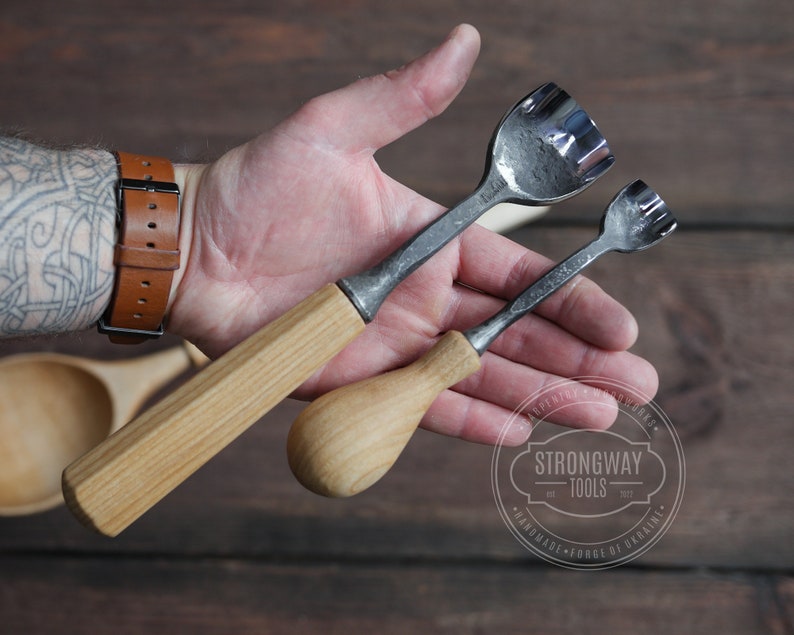 Pu&ograve; includere: Due strumenti da intaglio con manico in legno e lame in metallo. Gli strumenti hanno un design unico con pi&ugrave; denti sulla lama. Gli strumenti sono tenuti in una mano con un tatuaggio.