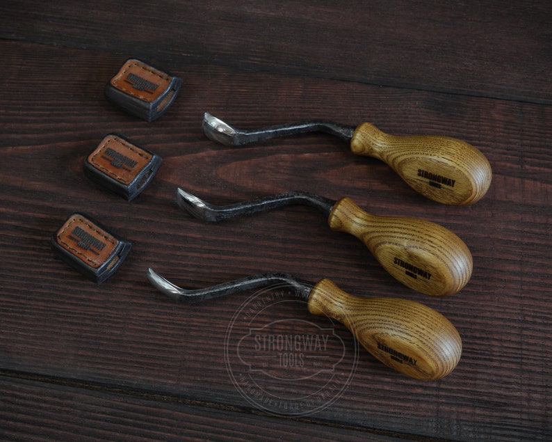May include: Three wood carving tools with brown wooden handles and black metal blades. The handles are engraved with the text "Strongway Tools".