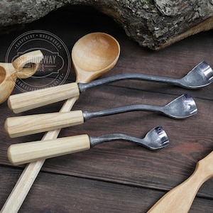 May include: Three wooden handled carving tools with metal blades. The tools are on a wooden surface with a wooden spoon and a wooden bowl.