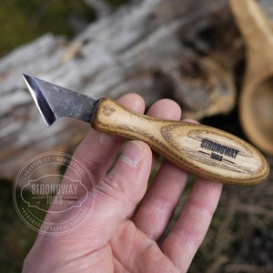 Puede incluir: Un pequeño cuchillo de talla de madera, afilado, con mango de madera. El mango está grabado con las palabras "Strongway Tools".
