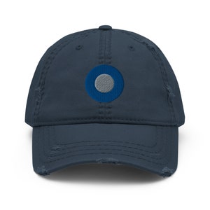 May include: A navy blue distressed baseball cap with a blue and gray circle embroidered on the front.