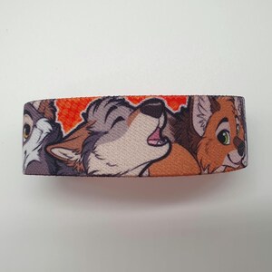 May include: A colorful wristband with a design featuring three cartoon animals: a wolf, a fox, and a dog. The animals are depicted in a playful and friendly manner, with the wolf howling and the fox smiling. The wristband is made of a soft and comfortable material, and it is perfect for adding a touch of personality to any outfit.