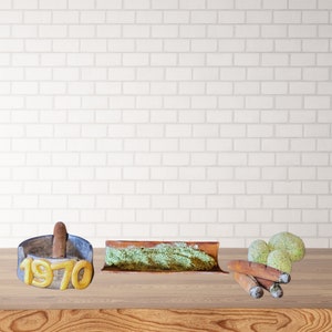 Könnte beinhalten: Ein Holztisch zeigt eine Sammlung von Gegenständen. Ein Aschenbecher mit dem Jahr "1970" in goldfarbenen Buchstaben, ein rechteckiges Tablett mit grün strukturierten Details, mehrere Zigarren und zwei kugelförmige Objekte mit strukturierter Oberfläche.