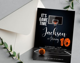 May include: A basketball-themed birthday invitation with a black background and a basketball hoop with a basketball going through the net. The text reads "It's Game Time Jackson is turning 10" with a basketball graphic. The date and time of the event are listed as "10 October 2025 - 7:00 PM" and the location is "Really Great Stadium - Any City - ST 12345". The invitation also includes the RSVP information: "RSVP to Cindy by October 1st".