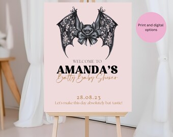 May include: A pink sign on an easel with a bat illustration and the text "WELCOME TO AMANDA'S Batty Baby Shower 28.08.23". The sign also includes the phrase "Let's make this day absolutely bat-tastic!" and "Print and digital options".