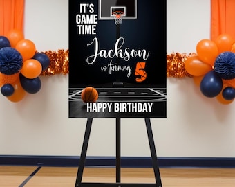 以下が含まれることがあります： 黒と白のバスケットボールをテーマにした誕生日サイン。"It's Game Time"と"Jackson is turning 5"の文字と、バスケットボールとバスケットボールのフープが黒の背景に描かれている。サインは黒いイーゼルに置かれている。
