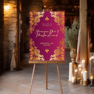 May include: A welcome sign for a wedding with a burgundy background and gold filigree design. The text reads "Welcome to Wedding of Viranjan Devi & Prasha Anand, Boston, MA July 05, 2030".