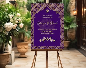 May include: A purple wedding welcome sign with gold decorative elements and text. The sign is on a wooden easel. The text reads "Welcome to the wedding of Sharya & Darsh, August 26, 2023, San Diego, California."