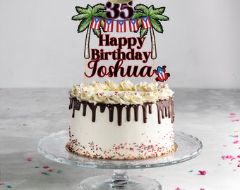 May include: A white cake with chocolate frosting and red and white sprinkles. The cake is decorated with a cake topper that says "35 Happy Birthday Joshua" with palm trees, flags, and a small figurine of a coqui frog.