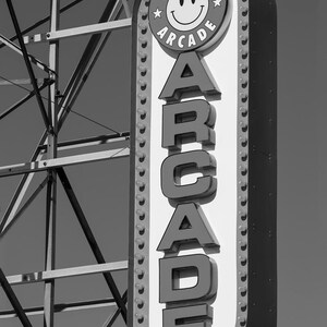 A black and white photograph of a vintage arcade sign on the Wildwood, NJ Boardwalk with gritty industrial details. Photography by Thomas Enson.