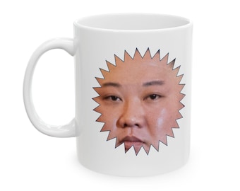 Può includere: Tazza da caffè in ceramica bianca con un'immagine stampata di un viso in una forma a stella.