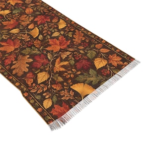 May include: A rectangular table runner featuring a dark brown background with a dense pattern of autumn leaves including maple, oak, and ginkgo in shades of orange, red, yellow, and green. The runner has a decorative border and white fringe.